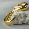 Gold hoop earrings on a textured surface