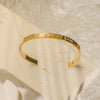 Gold bracelet with small stones on a beige surface