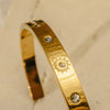 Gold bracelet with diamond accents on a light background