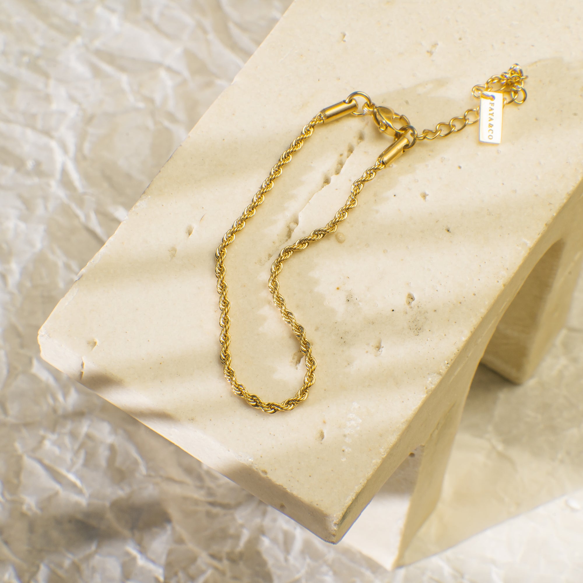 Gold bracelet with an intricate braided design.