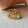Gold chain-link ring on a textured surface