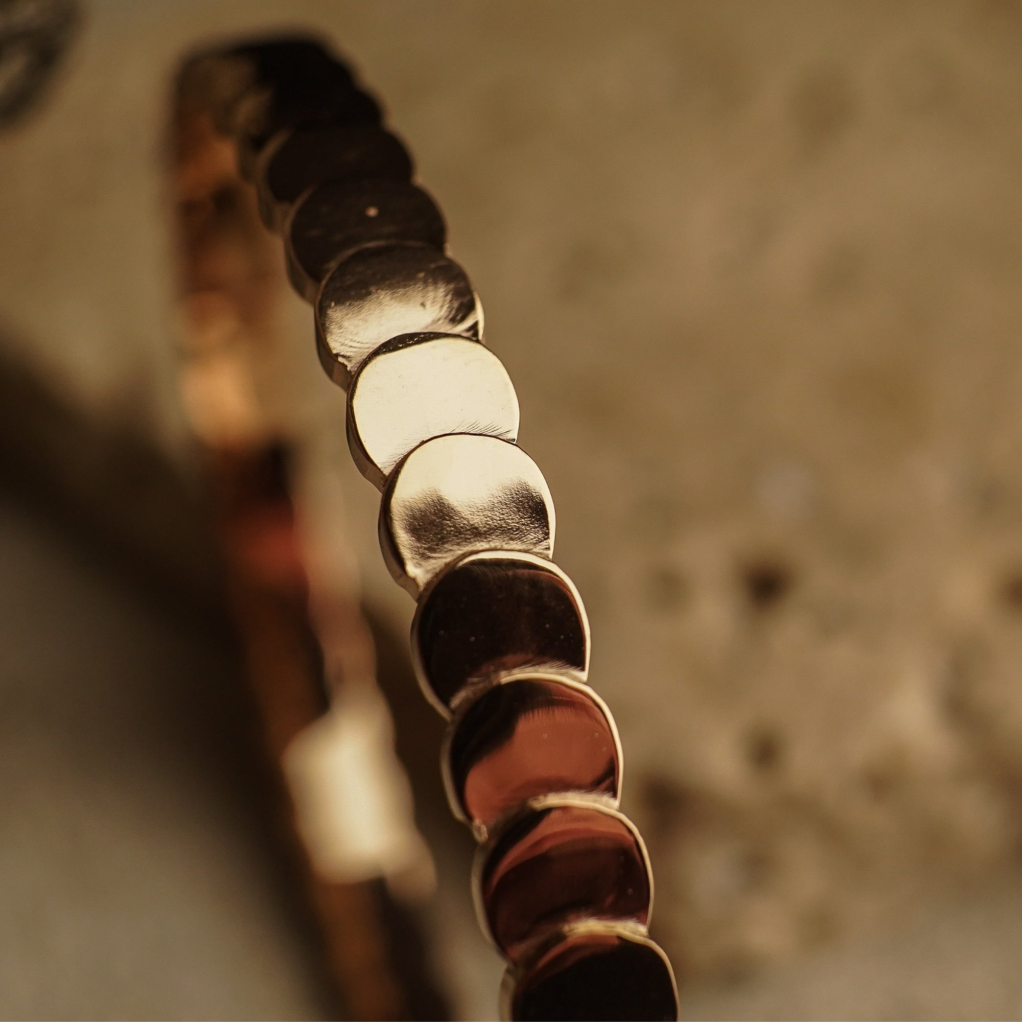 Close-up of a bracelet with circular beads on a blurred background