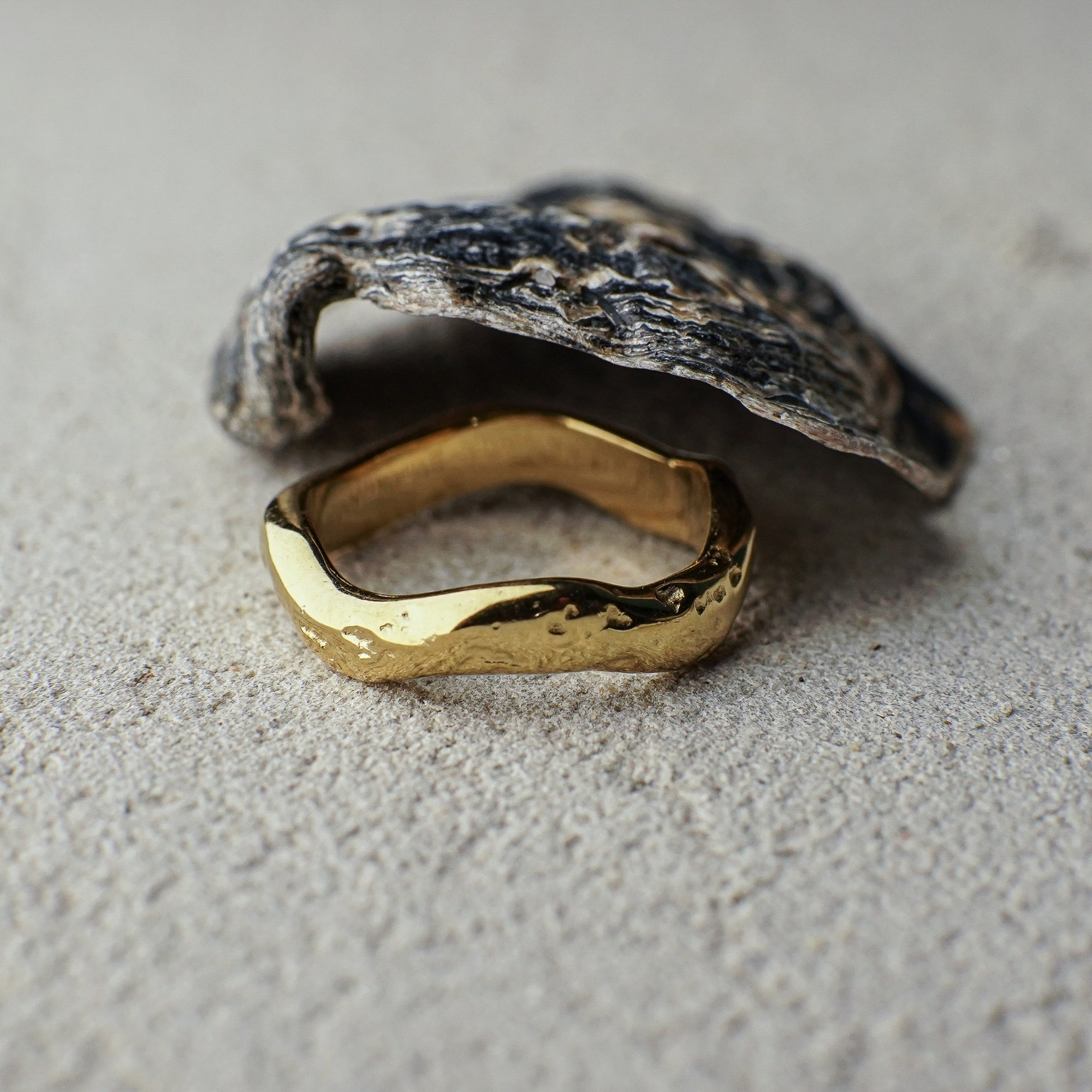 Gold ring with a textured stone on a gray surface
