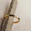 Gold ring with a diamond on a textured stone surface