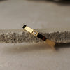 Gold bracelet with a diamond on a textured surface