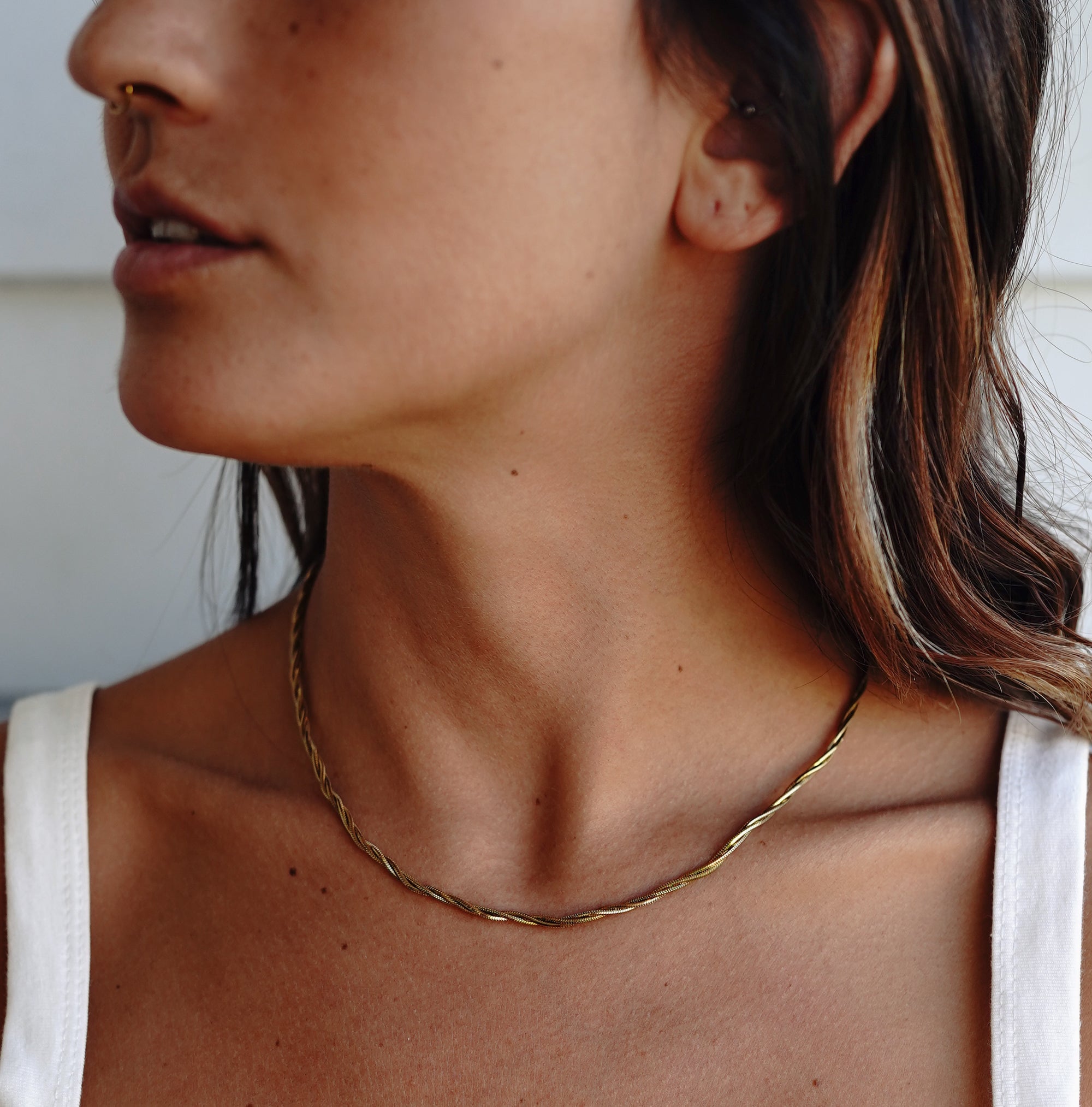 A model wearing Ines Twisted Gold Necklace