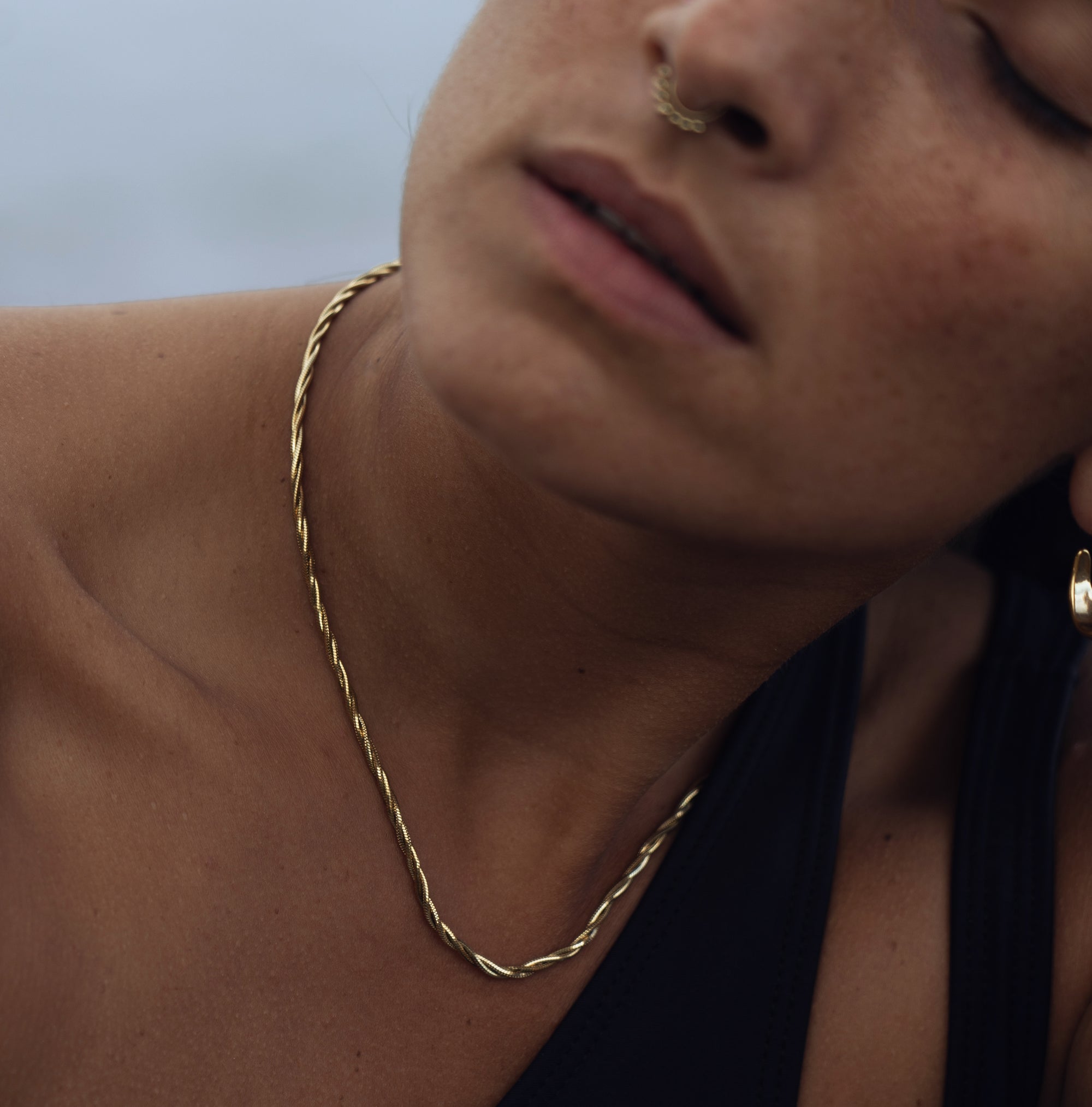 A model wearing Ines Twisted Gold Necklace
