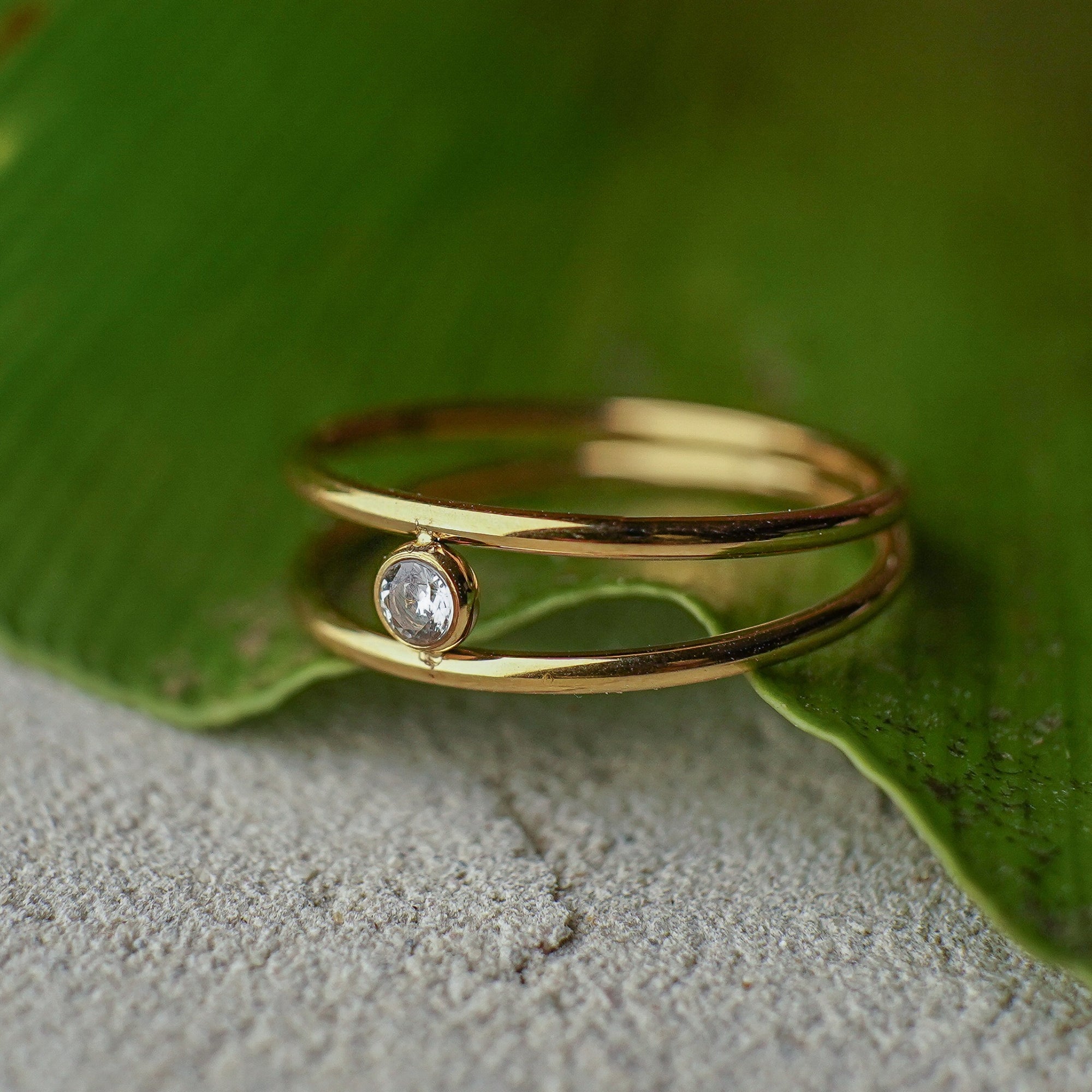 Gold ring with a diamond on a green leaf