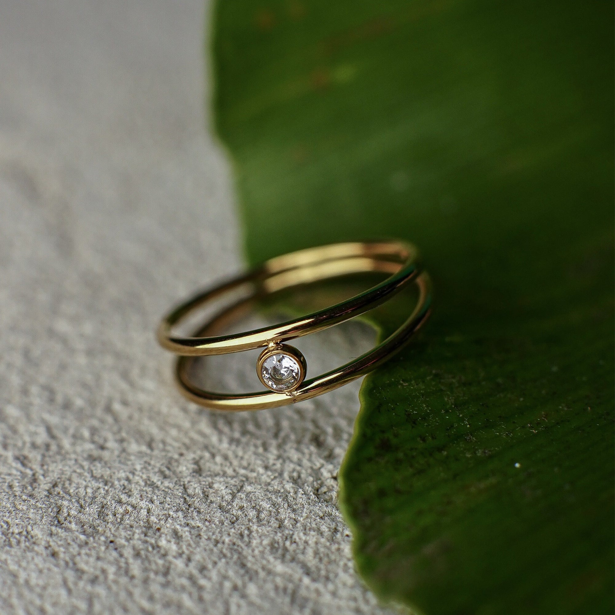 Gold ring with a diamond on a green leaf