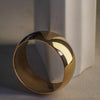 Gold bangle on a textured surface with a neutral background
