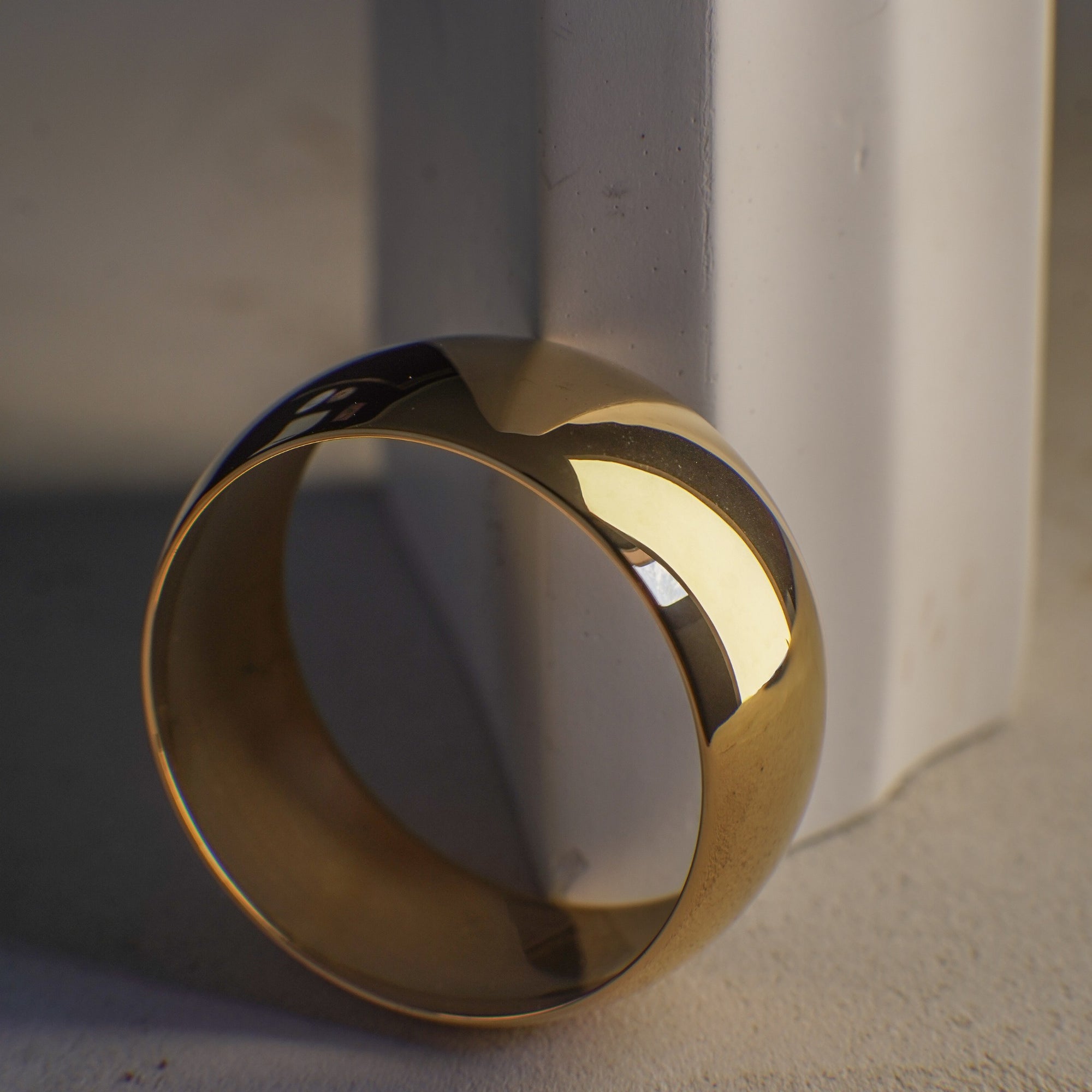 Gold bangle on a textured surface with a neutral background
