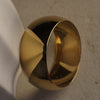 Gold bangle on a textured beige surface