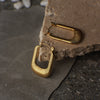 Gold hoop earrings on a textured stone surface