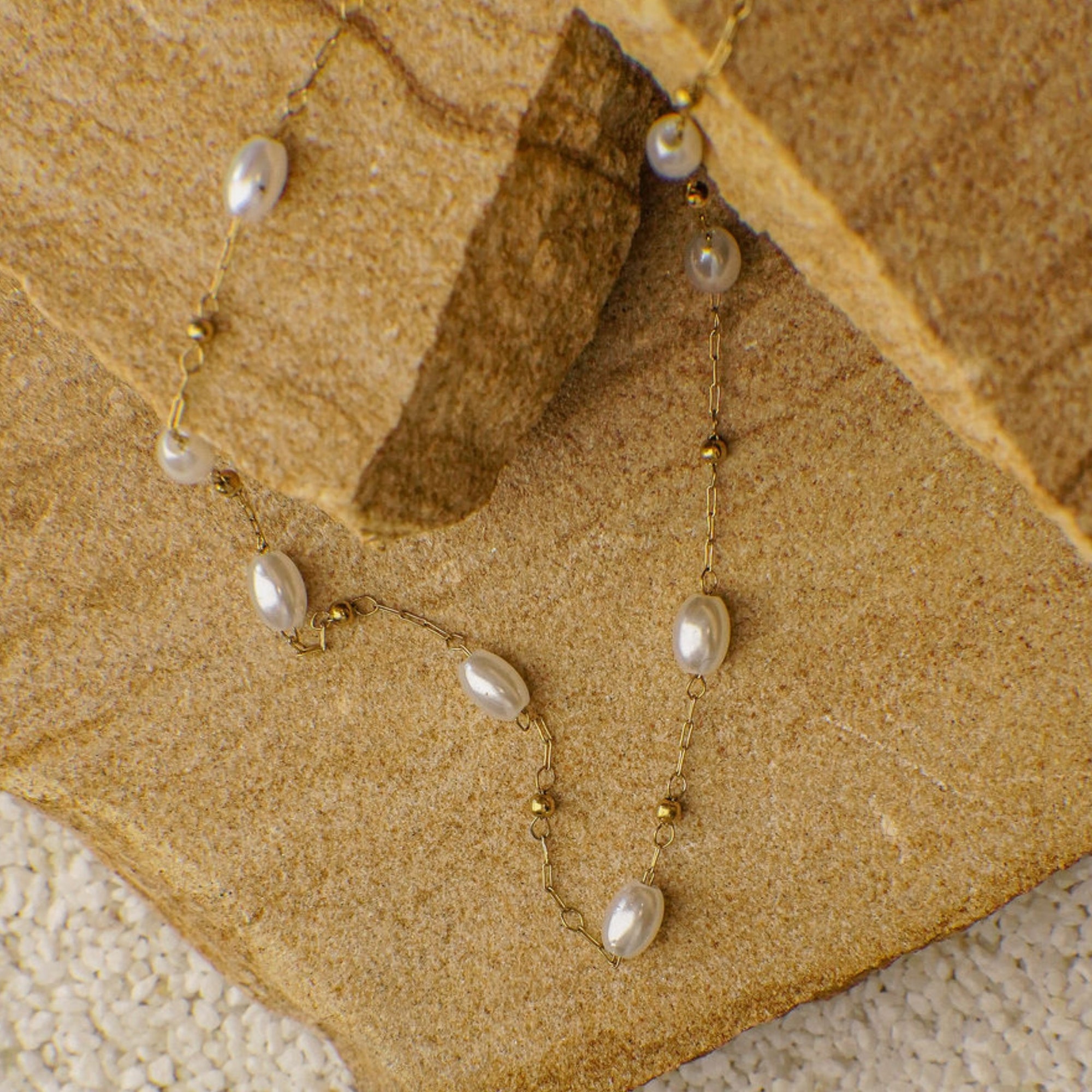Pearl necklace on a textured beige surface