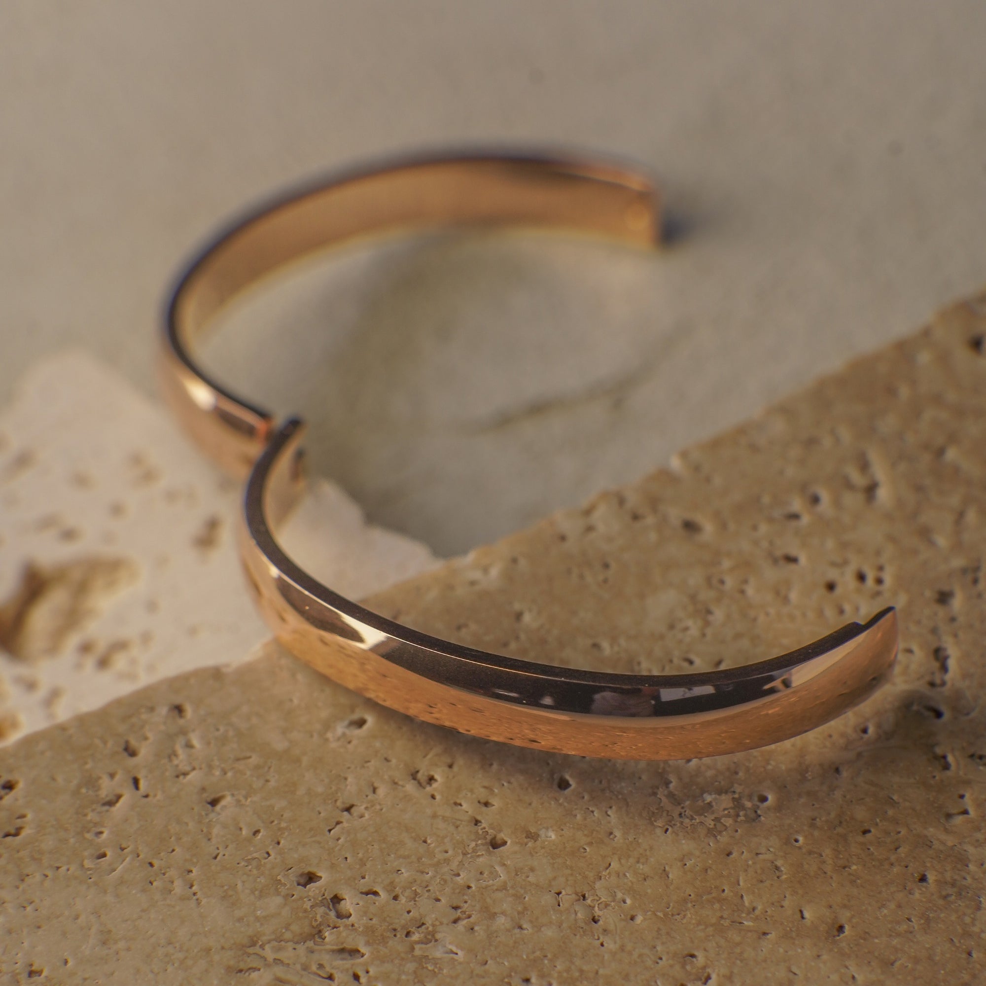 Gold bracelet on a textured stone surface