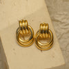 Pair of gold hoop earrings on a beige stand