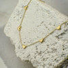 Gold heart-shaped necklace on a textured stone surface
