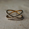 Two interlocking rings with pearl detailing on a textured surface