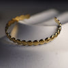 Gold bracelet on a textured surface