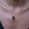 A model wearing a gold necklace with star engraved pendant