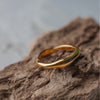 Gold ring on a textured brown surface with a blurred gray background