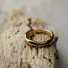 Gold ring on a textured wooden surface