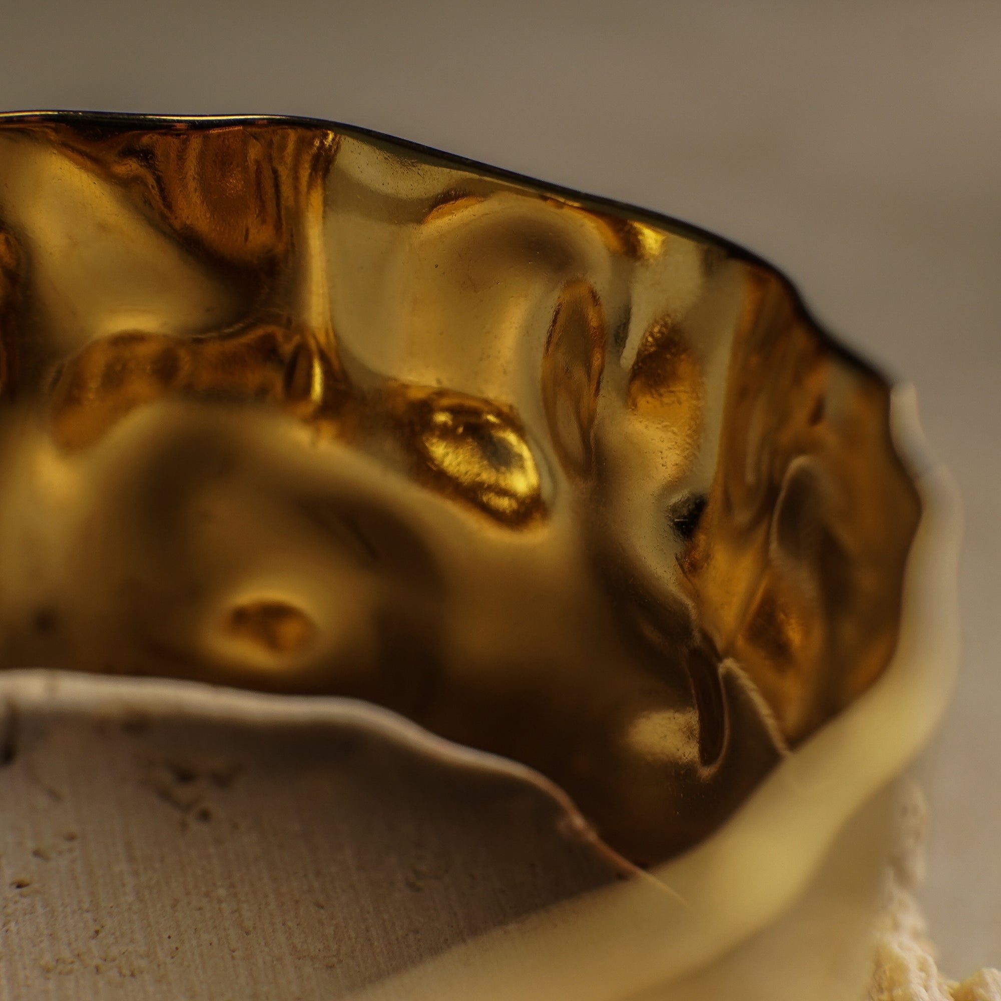 Close-up of a gold-colored ceramic bowl with a textured surface.