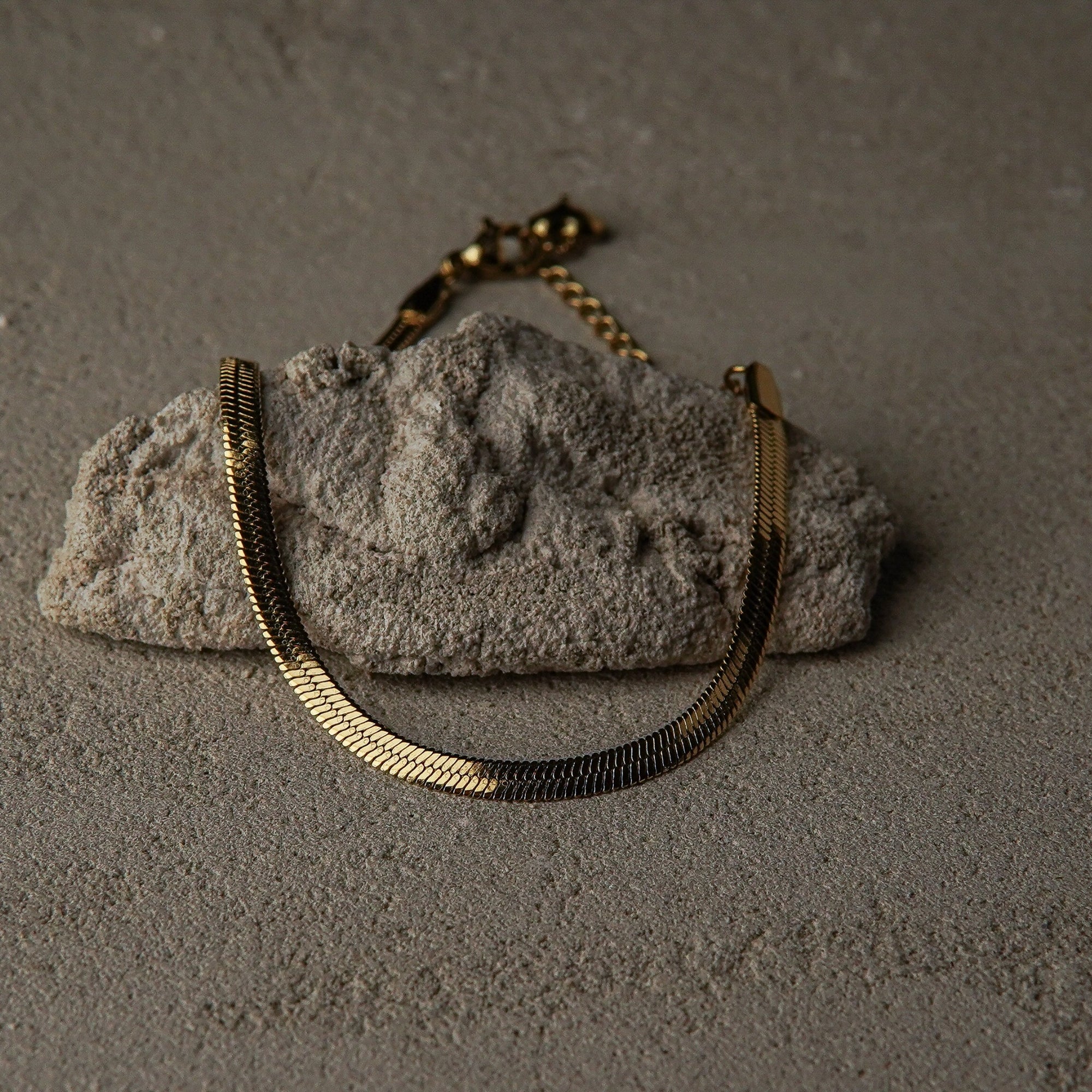 Gold bracelet on a textured stone surface