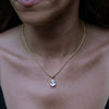 A model wearing a gold necklace with big zirconia pendant