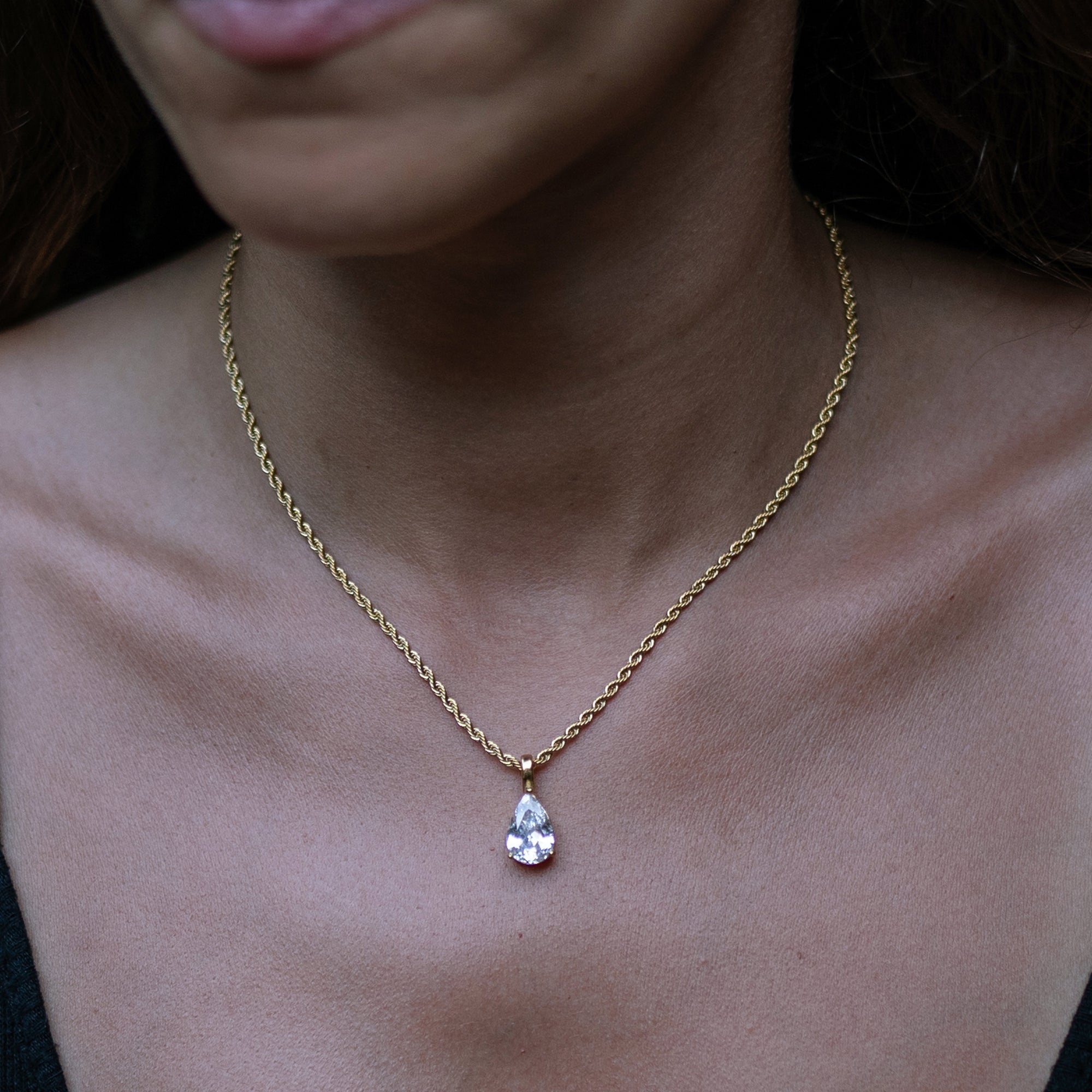 A model wearing a gold necklace with big zirconia pendant