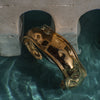 Gold ring on a stone surface with water reflection