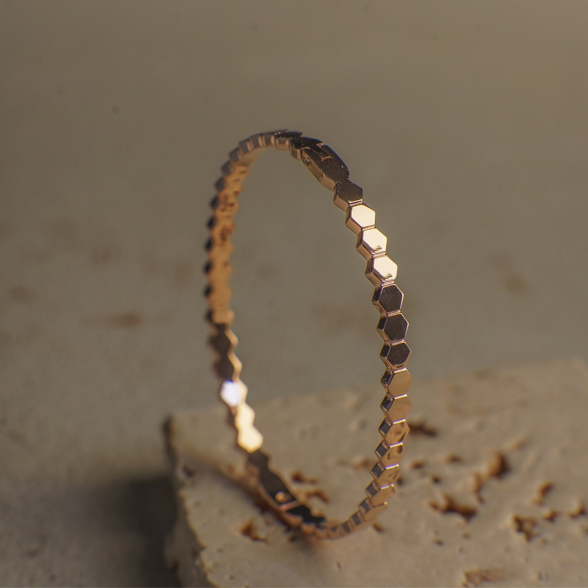 Gold hexagonal patterned ring on a textured surface