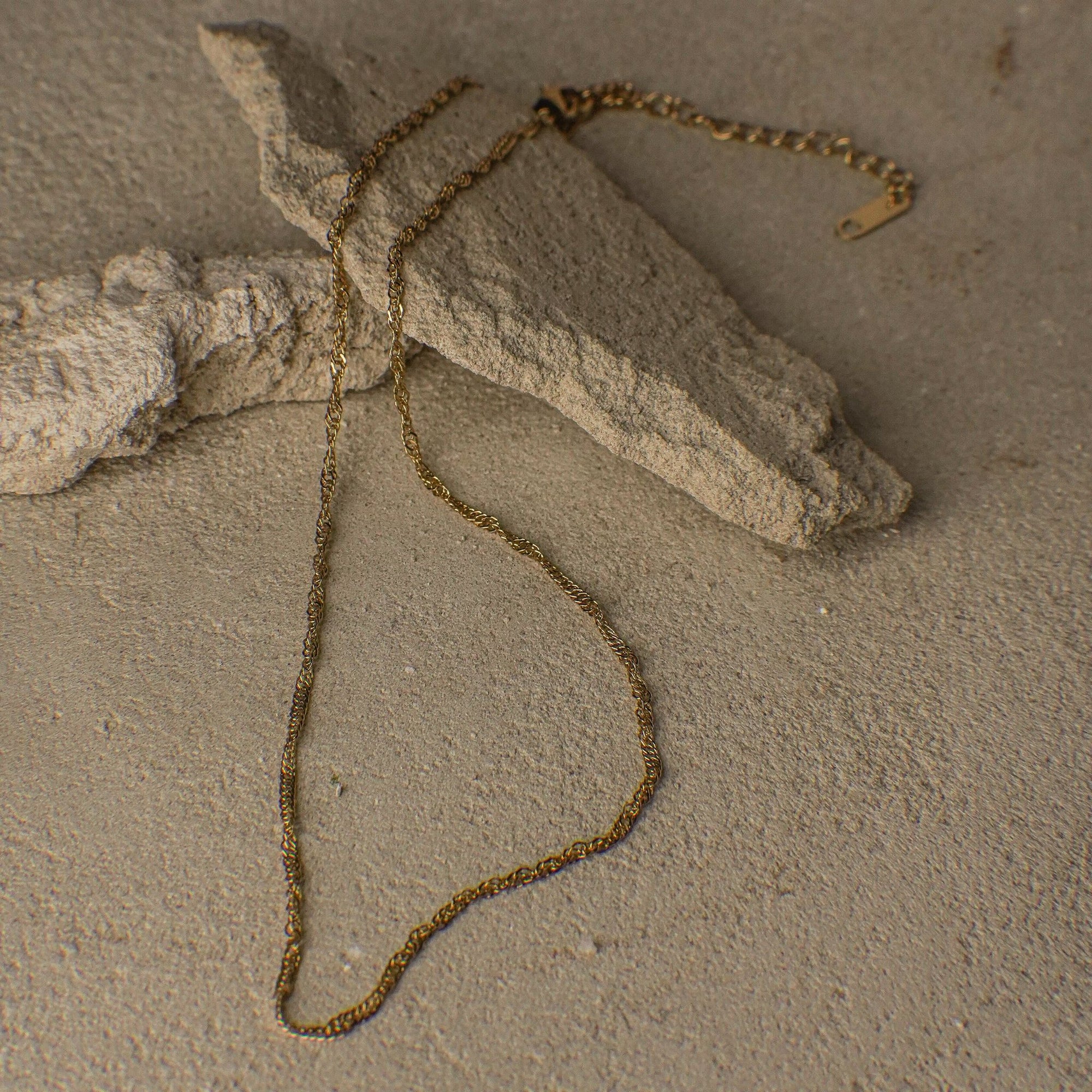 Gold chain on a textured surface