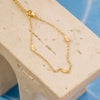 Gold necklace on a beige stand with a blue background