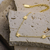 Gold bracelet with sunburst designs on a textured stone surface