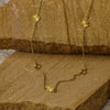 Gold necklace with floral pendants on a wooden surface