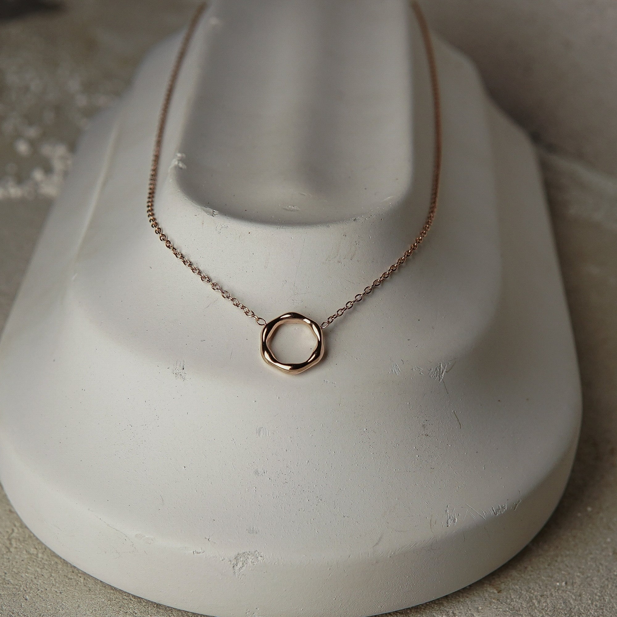 Rose gold necklace on a white mannequin bust