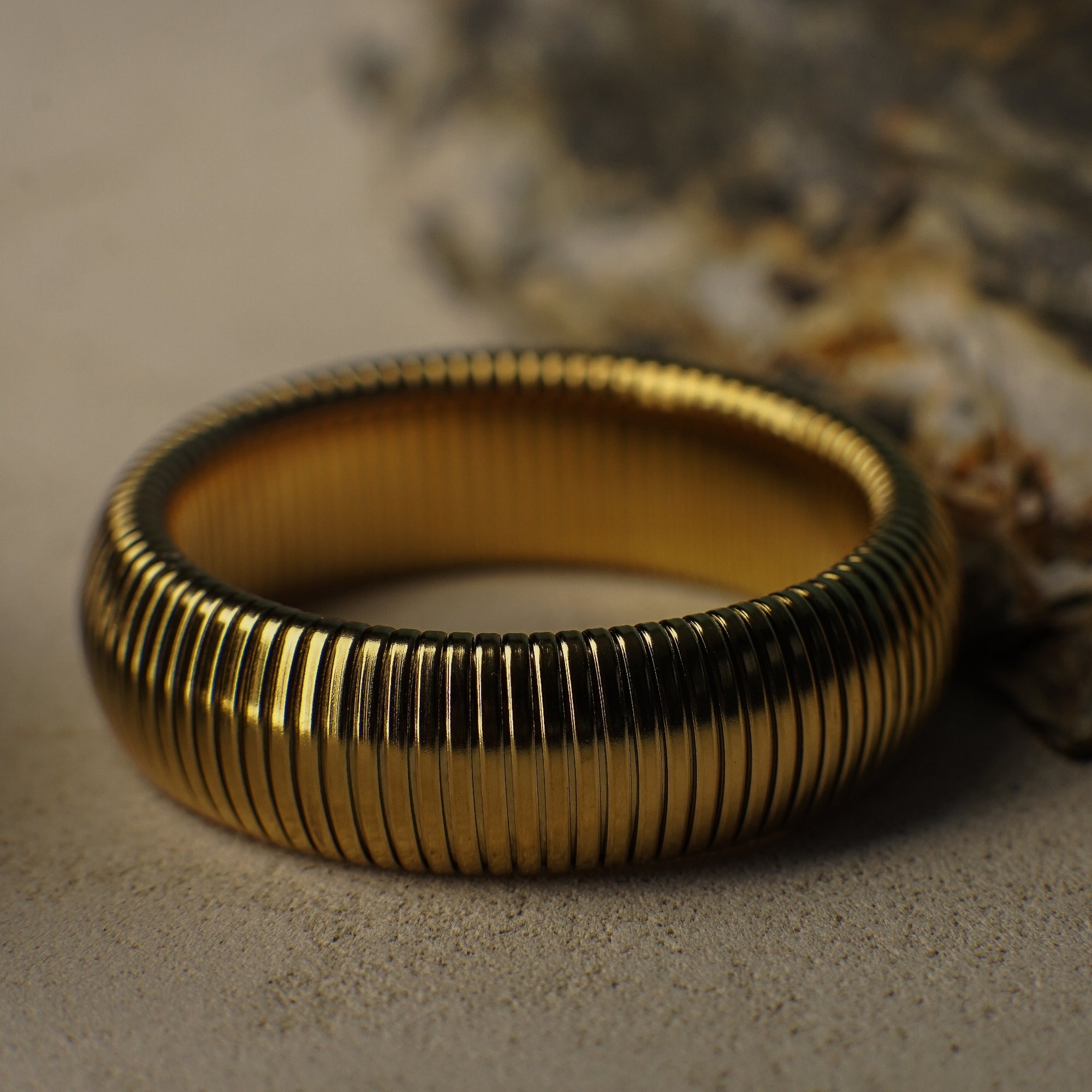 Gold ring with ribbed texture on a textured surface