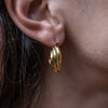 A woman wearing the Ottilie Gold Hoop Earrings on her right ear