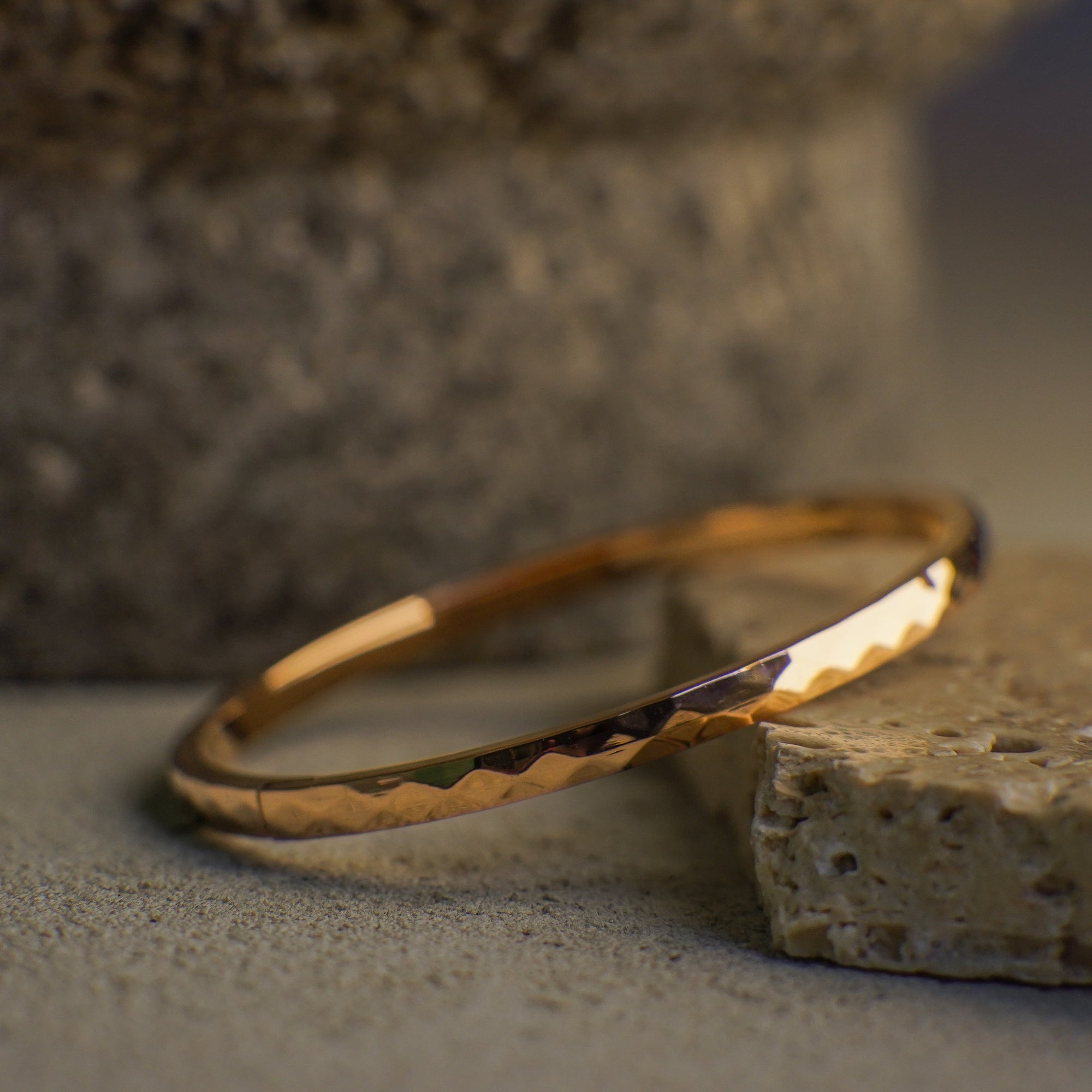 Gold bracelet on a textured stone surface