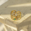 Gold ring with a green gemstone on a textured surface