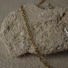 Gold chain on a textured stone surface