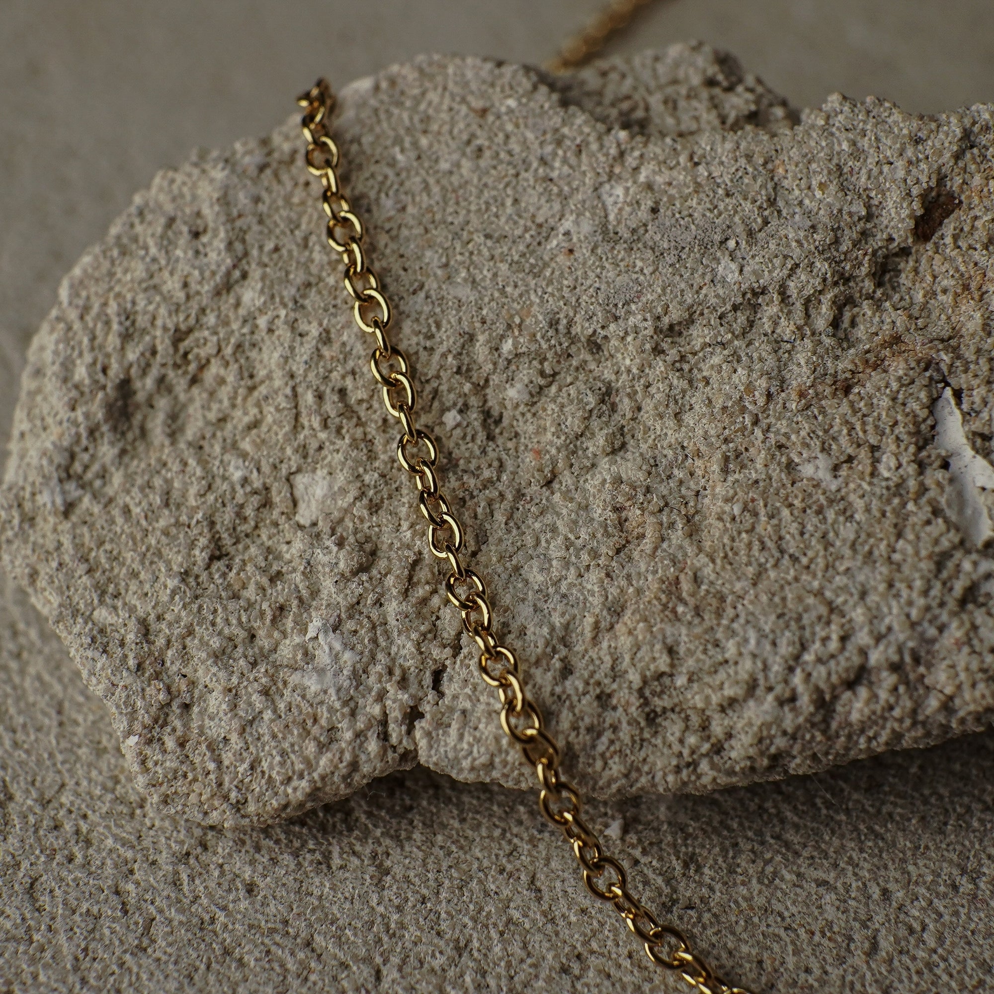 Gold chain on a textured stone surface