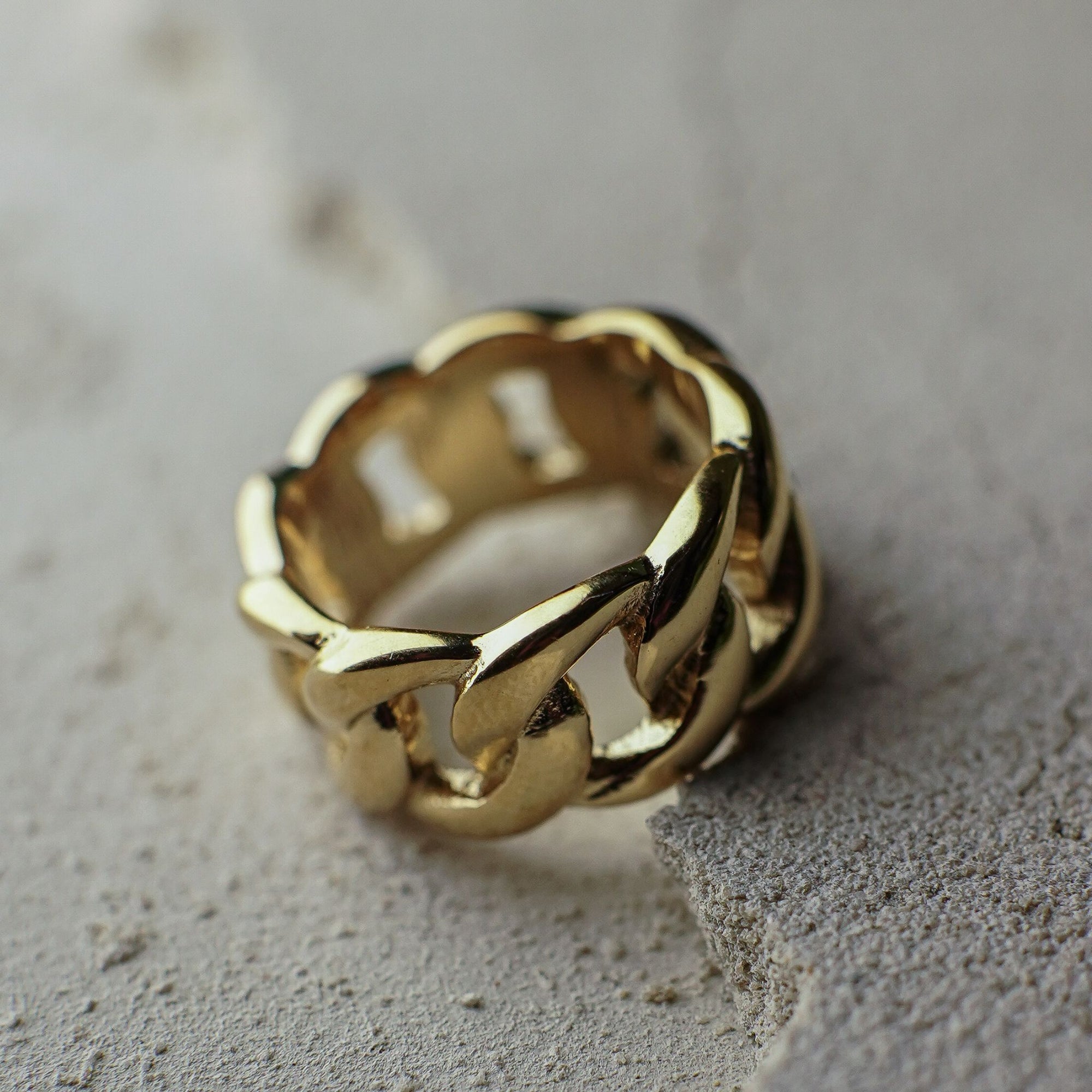 Gold chain ring on a textured surface