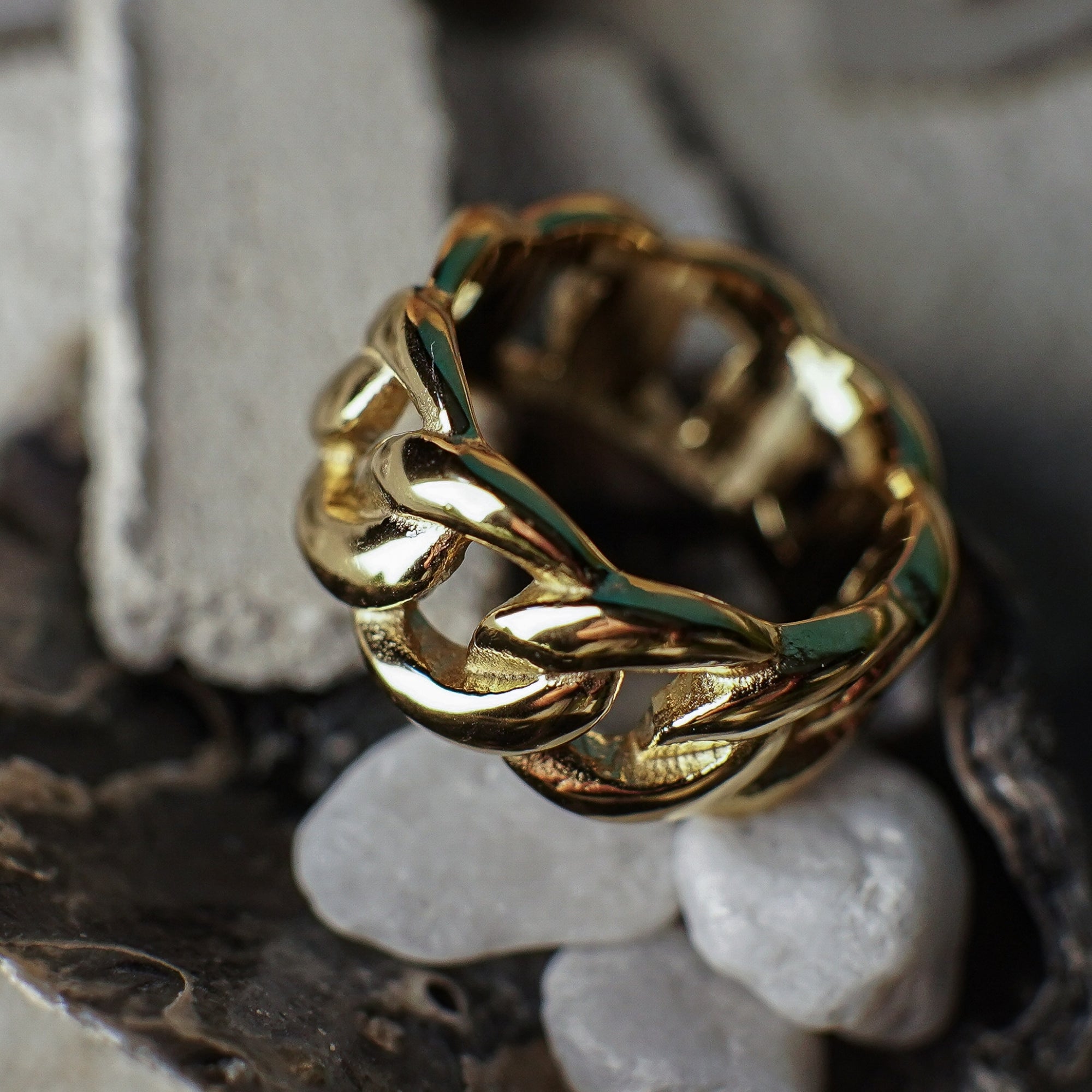 Gold knotted ring on a textured stone surface