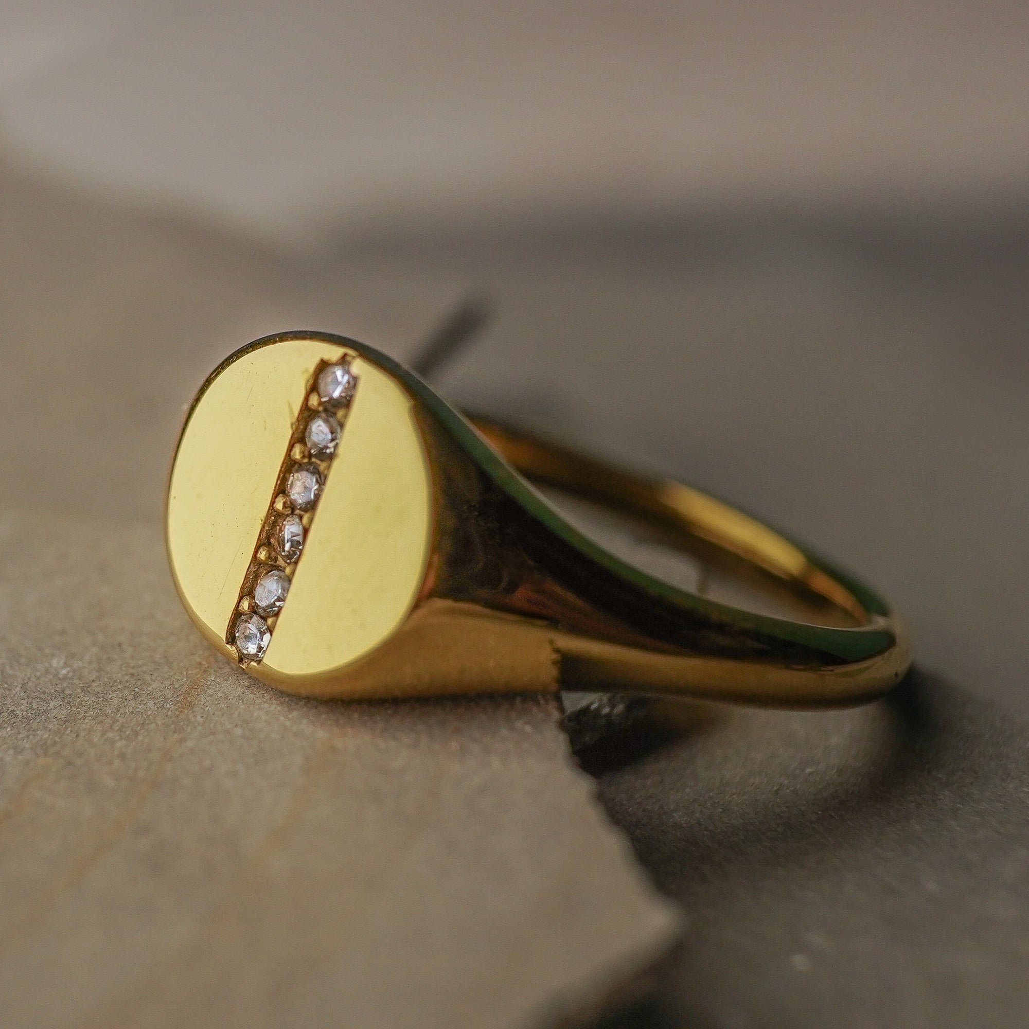 Gold ring with small diamonds on a textured surface