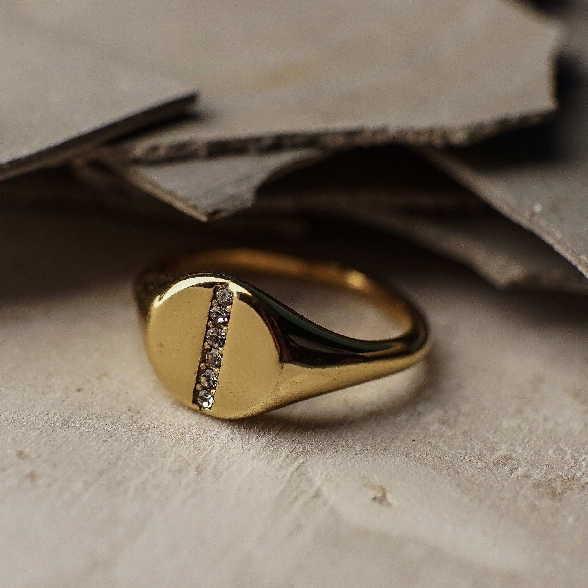 Gold ring with small diamonds on a textured surface