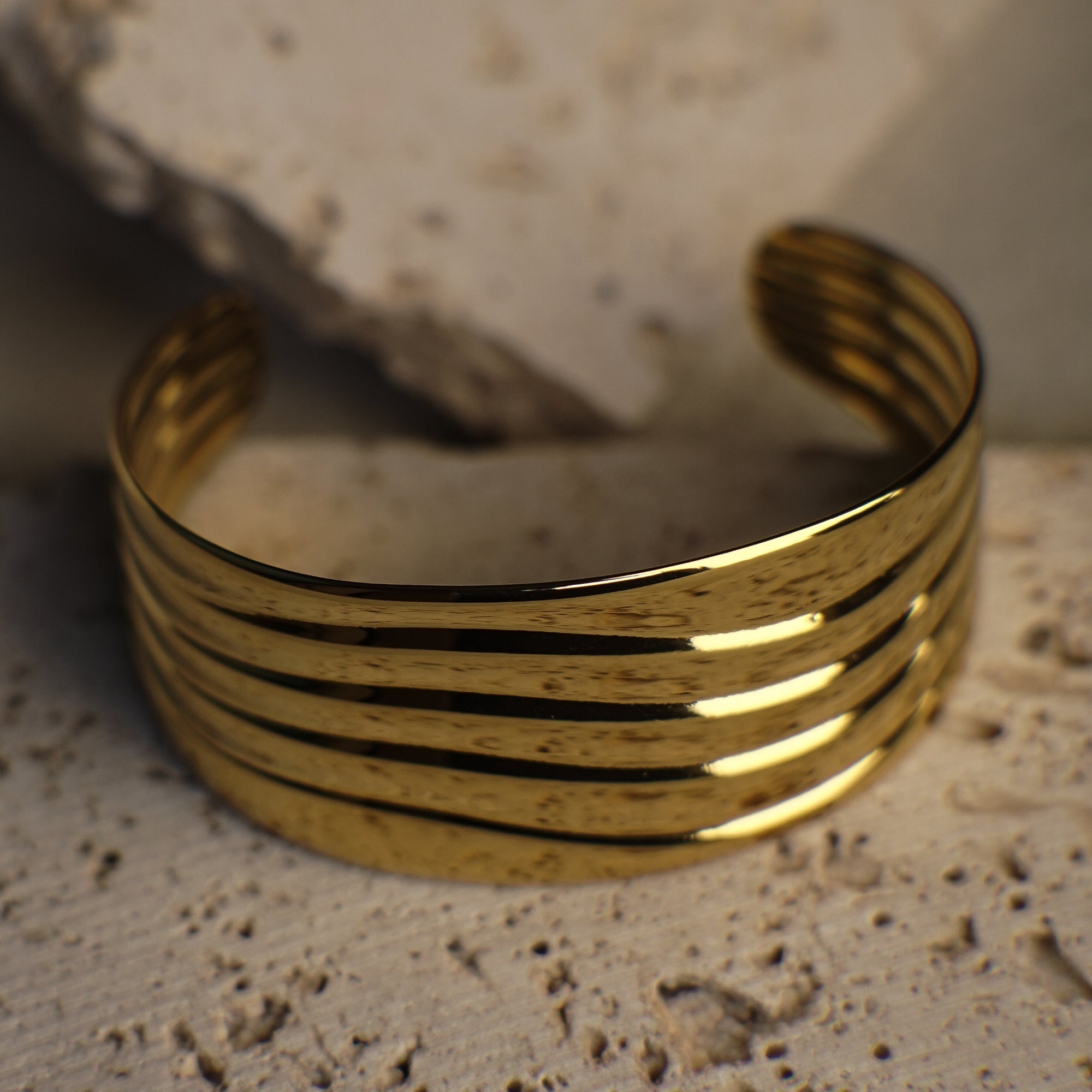 Gold bracelet on a textured stone surface