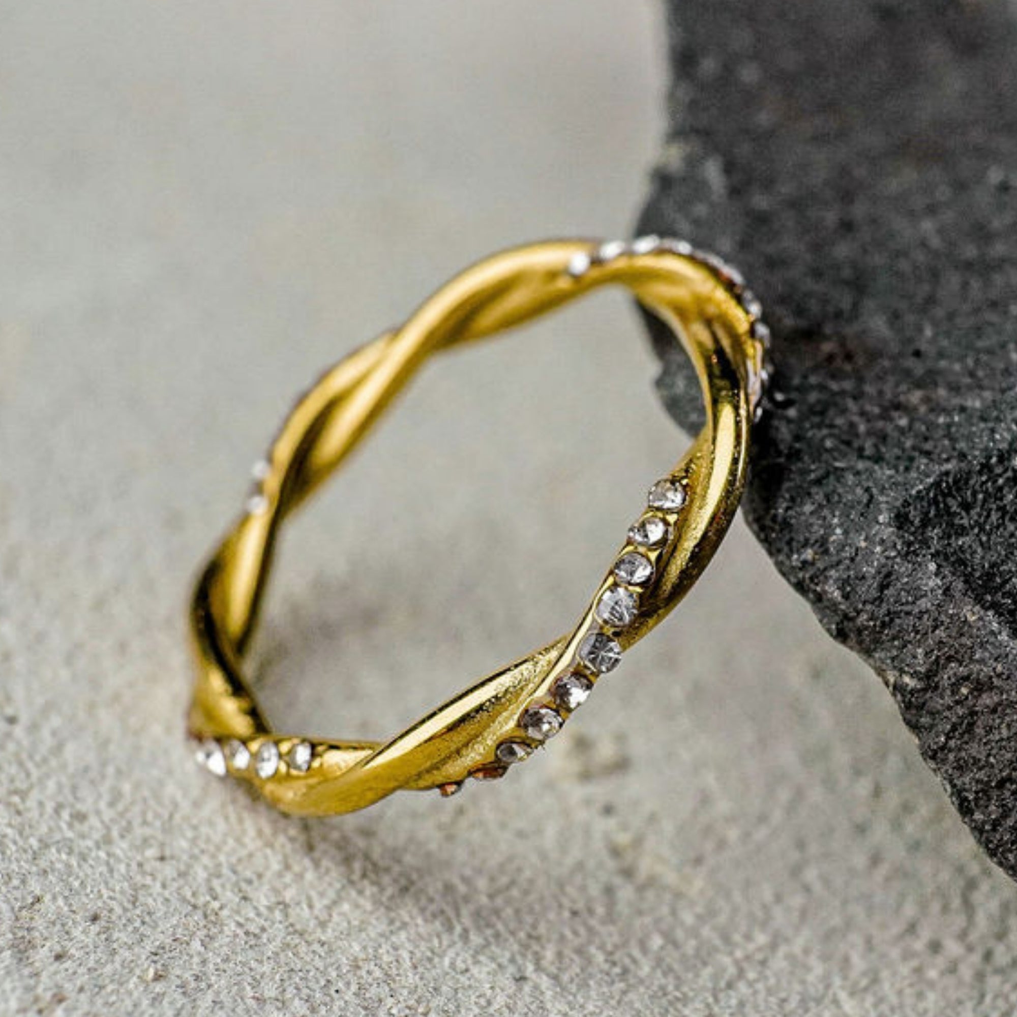 Gold ring with small diamonds on a stone surface