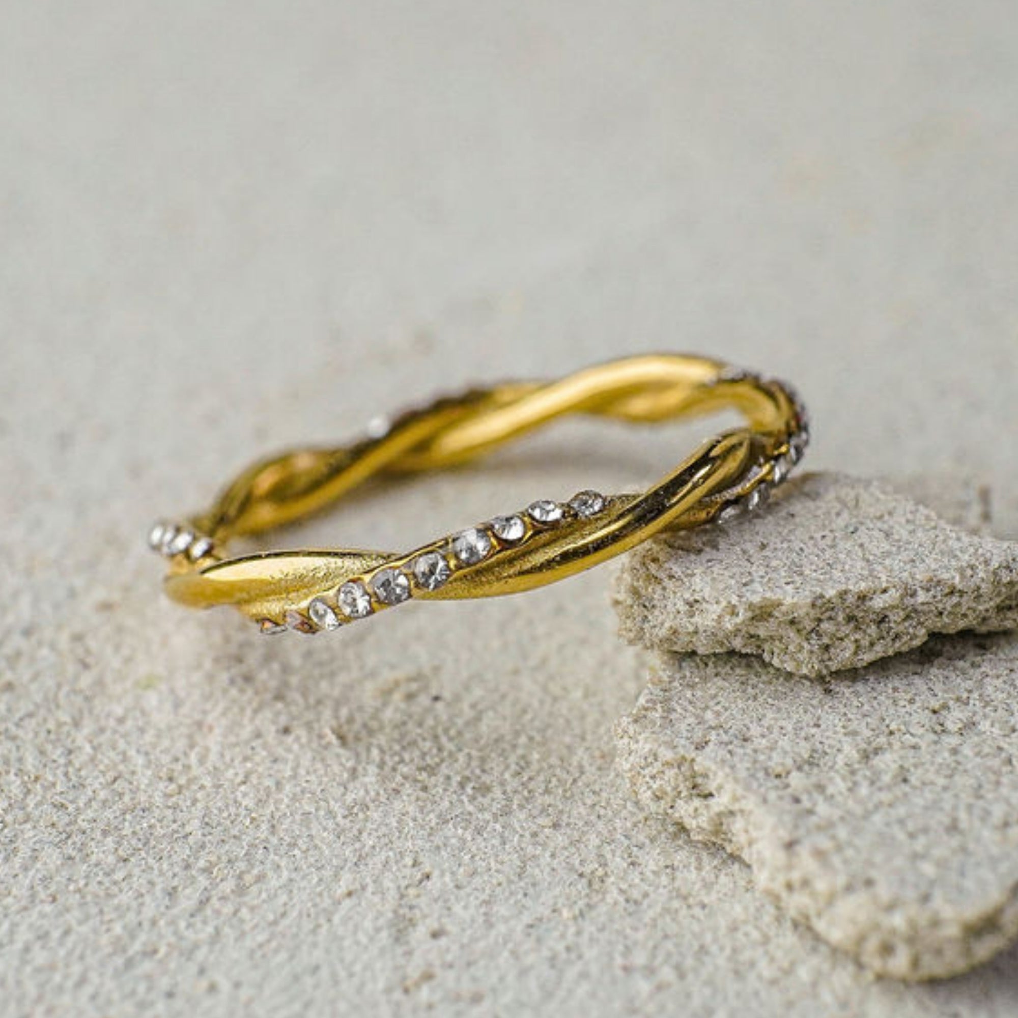 Gold bracelet with small stones on a stone surface